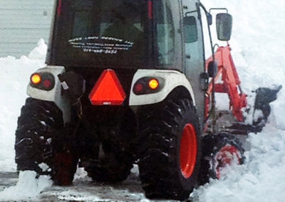 Tractor Plowing Snow in Driveway